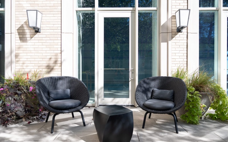 chairs outside of a brick building with a glass door behind them