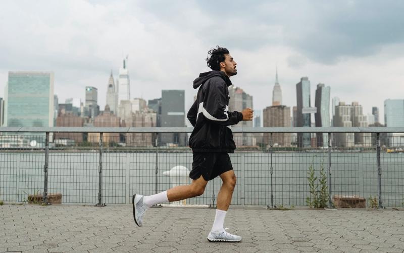 a person running on a stone path with a city skyline in the background